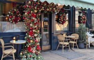 Χριστουγεννιάτικο καφέ με festive διακόσμηση, γιρλάντες και ζεστή ατμόσφαιρα, ιδανικό για επαγγελματικό χώρο με Christmas music